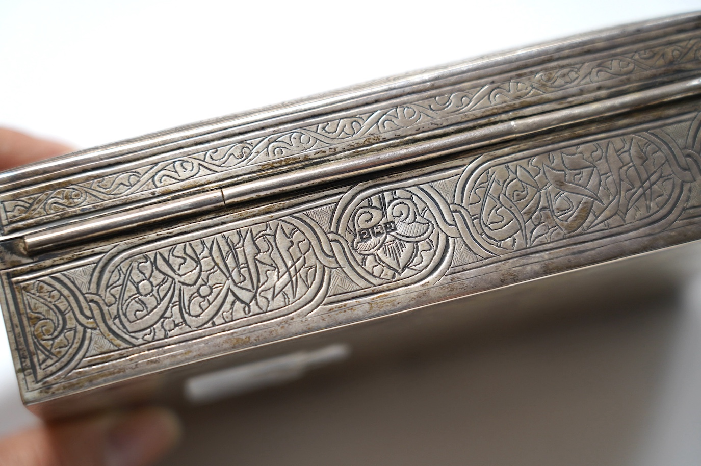 A Middle Eastern engraved white metal rectangular cigarette box, 12.5cm. Condition - fair